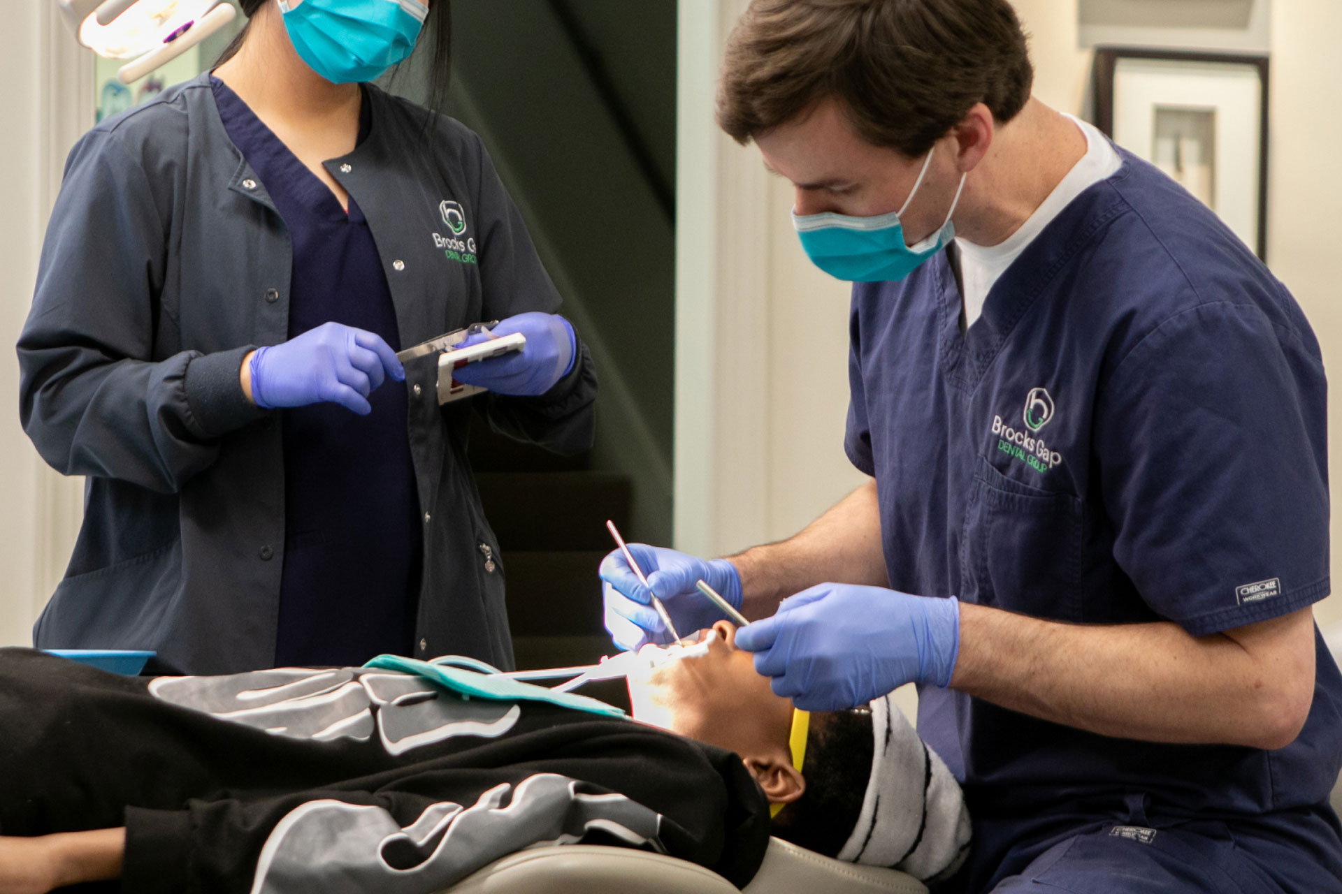 dr. jones and assistant performing oral exam on patient